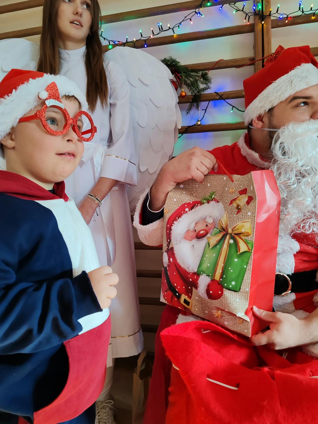 Niezapomniane spotkanie z Mikołajem! | Chłopiec w czerwonej czapce i w okularach na zdjęciu z Mikołajem.jpg