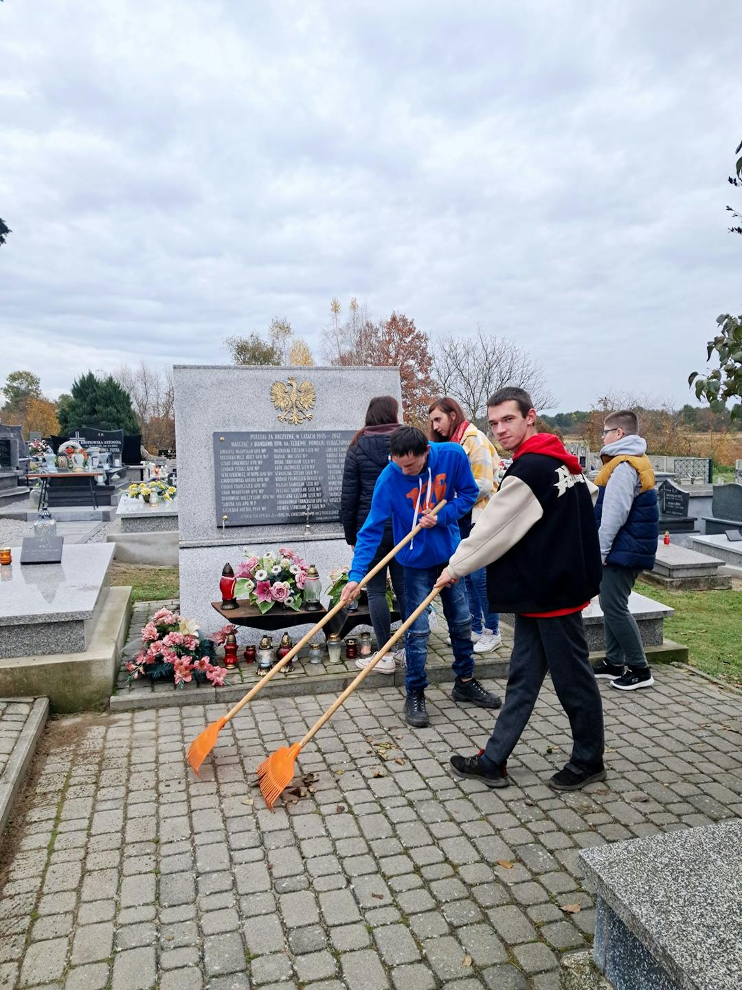 Szkoła pamięta… | Uczniowie grabia liście na cmentarzu.jpg