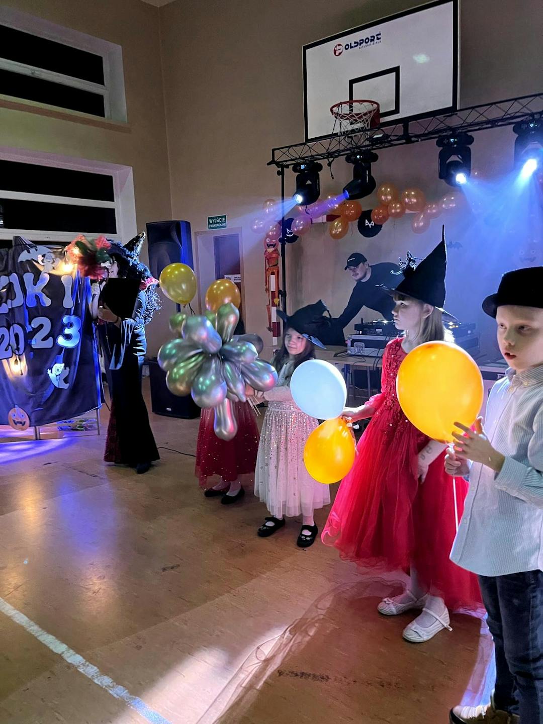 Andrzejki w internacie | Dzieci z balonami stoją w rzędzie na środku sali.jpg