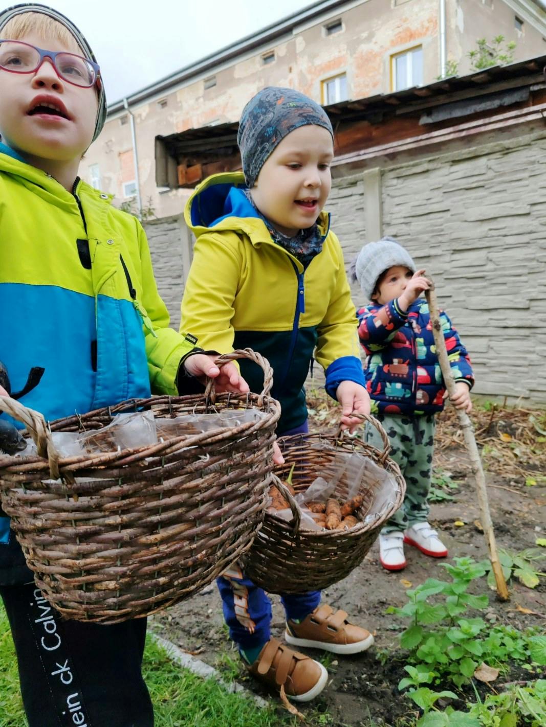Jesienne prace w ogrodzie | Dzieci trzymają koszyki z warzywami.jpg