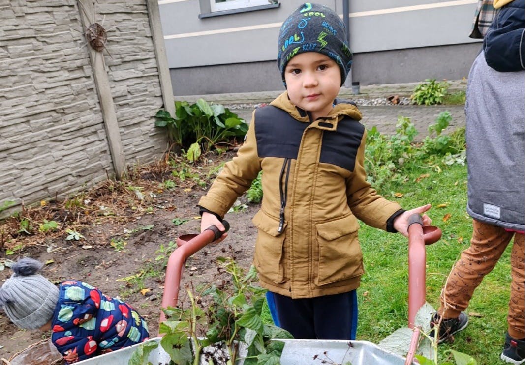 Jesienne prace w ogrodzie | Chłopiec trzyma taczki.jpg
