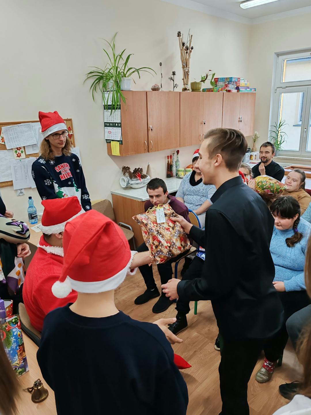 Niezapomniane spotkanie z Mikołajem! | Uczeń stoi przed Mikołajem, dookoła inni uczniowie.jpg