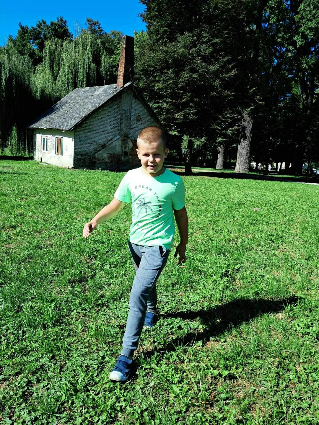 Spacer po parku w poszukiwaniu jesieni | Chłopiec radośnie biega po trawie w parku_.jpg