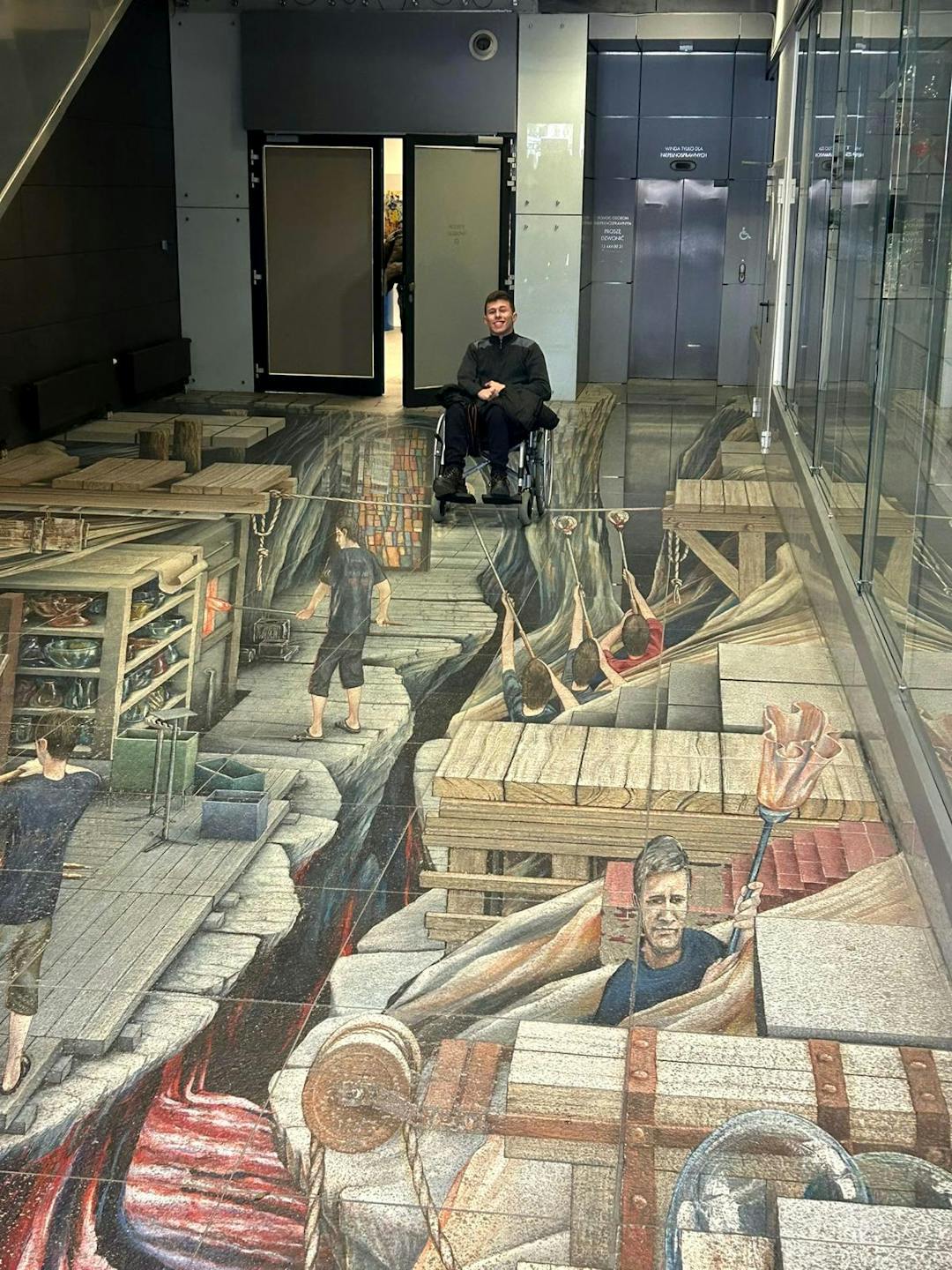 Szklane dziedzictwo Krosna | Uczeń na wózku oglada malowidła na podłodze.jpg