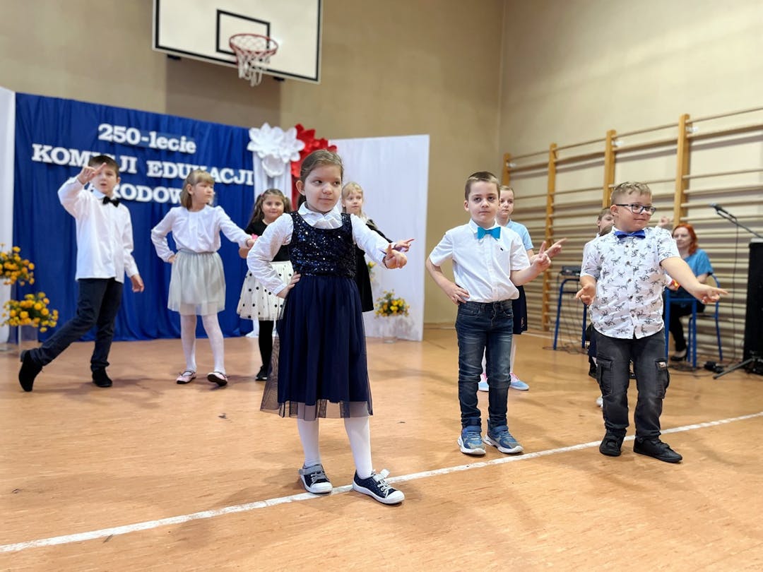 Świętujemy Dzień Edukacji Narodowej | Dzieci ustawione w dwóch rzędach tańczą na scenie.JPG