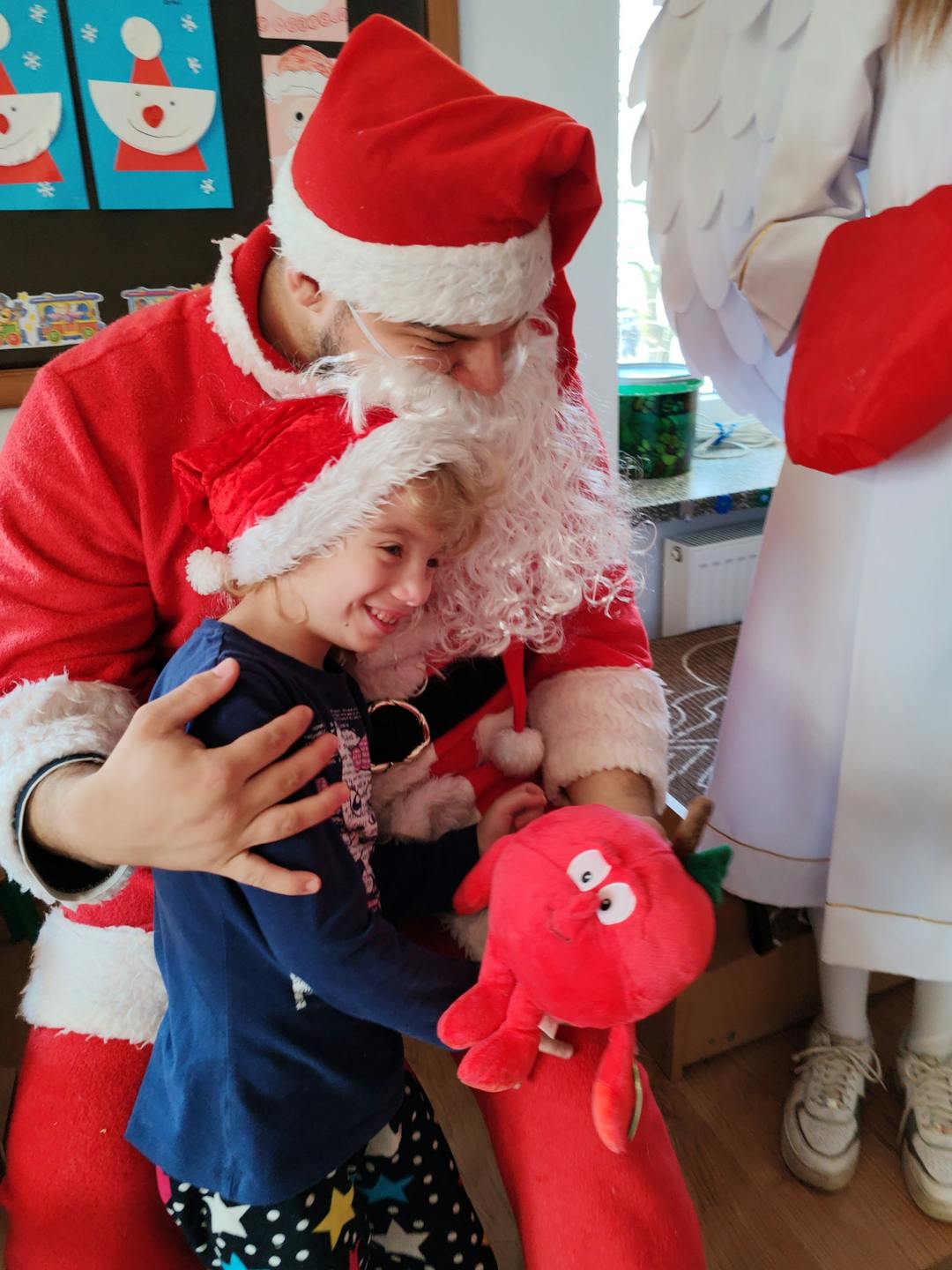 Niezapomniane spotkanie z Mikołajem! | Dziewczynka przytula się do Mikołaja.jpg