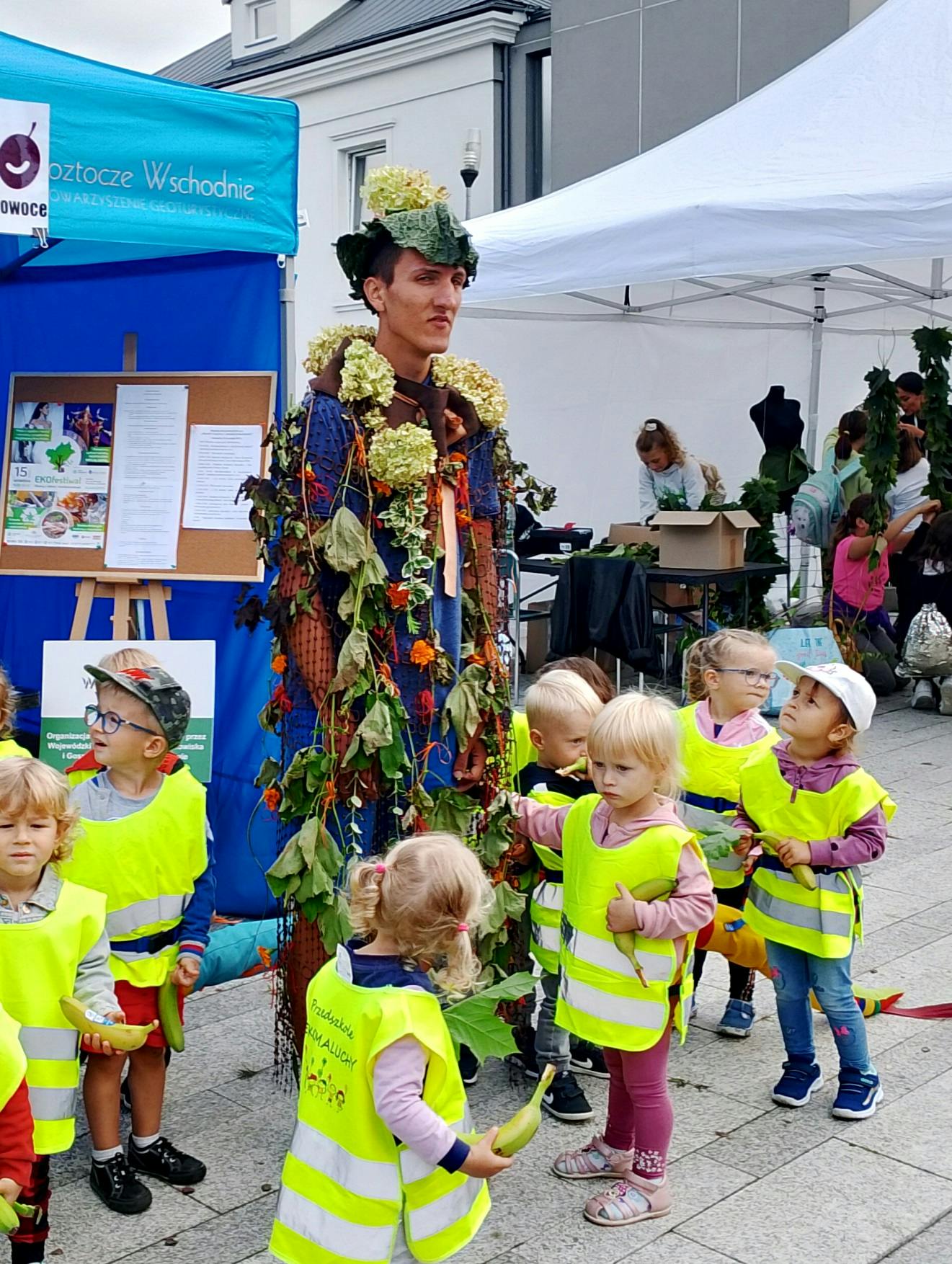 I miejsce dla Marka na EKOfestiwalu | 1. Uczeń w stroju ekologicznym z darów jesieni. Dookoła niego małe dzieci w kamizelkach odblaskowych.jpg
