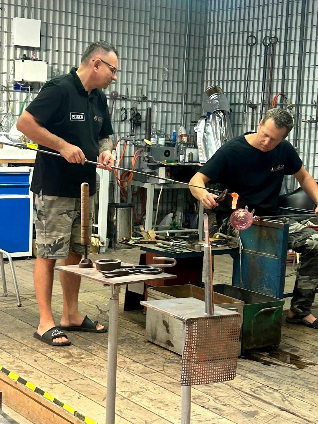 Szklane dziedzictwo Krosna | dwóch mężczyzn prezentuje proces produkcji szkła.jpg