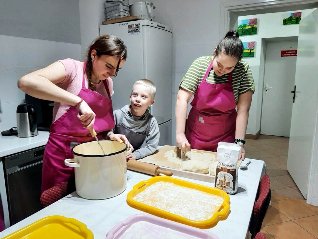 Kulinarne eksperymenty | Dwie dziewczyny przygotowują ciasto i farsz na pierogi, chłopiec się przygląda.jpg