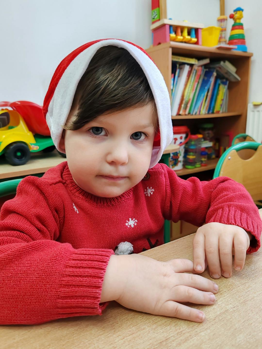Niezapomniane spotkanie z Mikołajem! | Chłopczyk w czapce Mikołaja przy stoliku.jpg