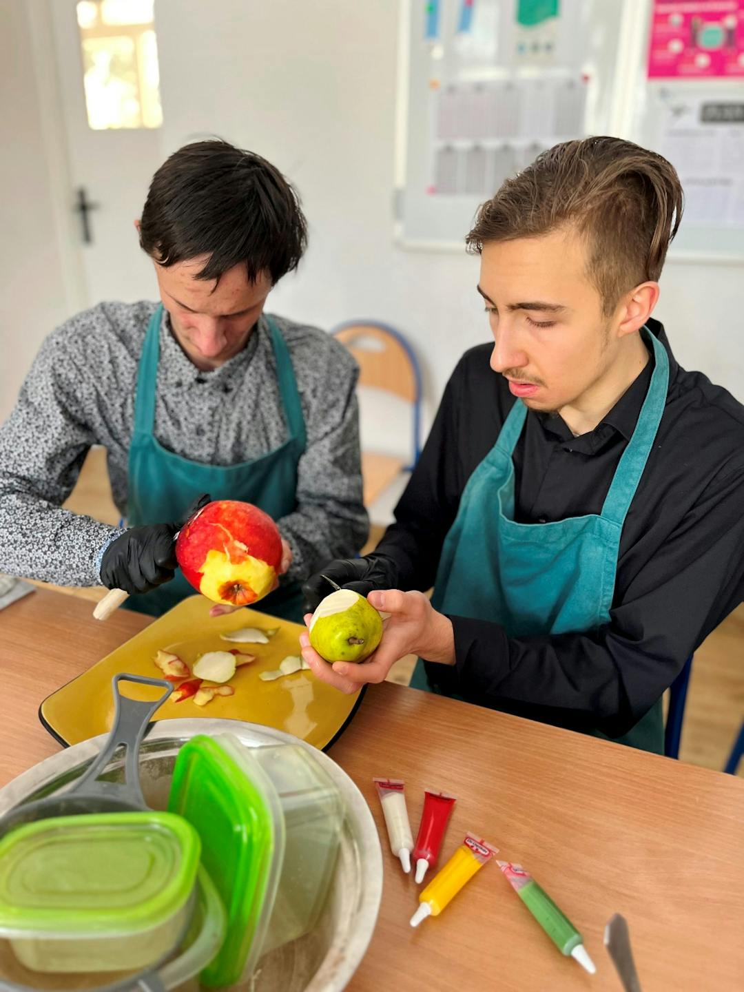 Przedświąteczne warsztaty kulinarne | dwóch uczniów obiera jabłka ze skórki.JPG
