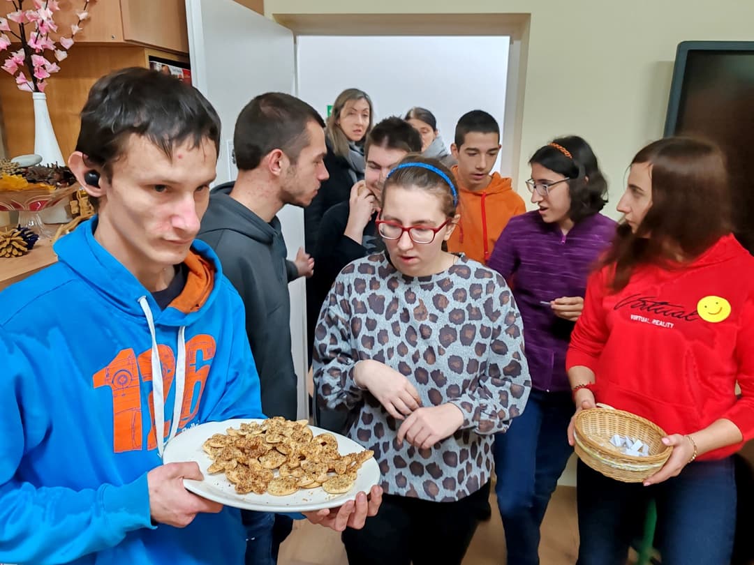 Dzień Życzliwości i Pozdrowień | Grupa uczniów, chłopiec trzyma ciastka na talerzu .jpg