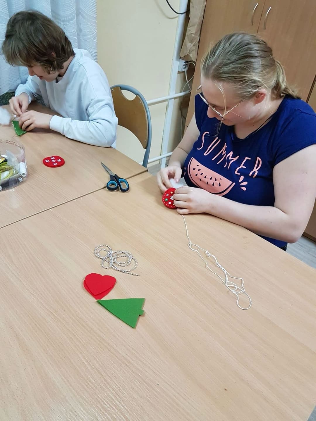 Zajęcia krawieckie w internacie | Dwie dziewczyny szyją ręcznie ozdoby choinkowe.jpg