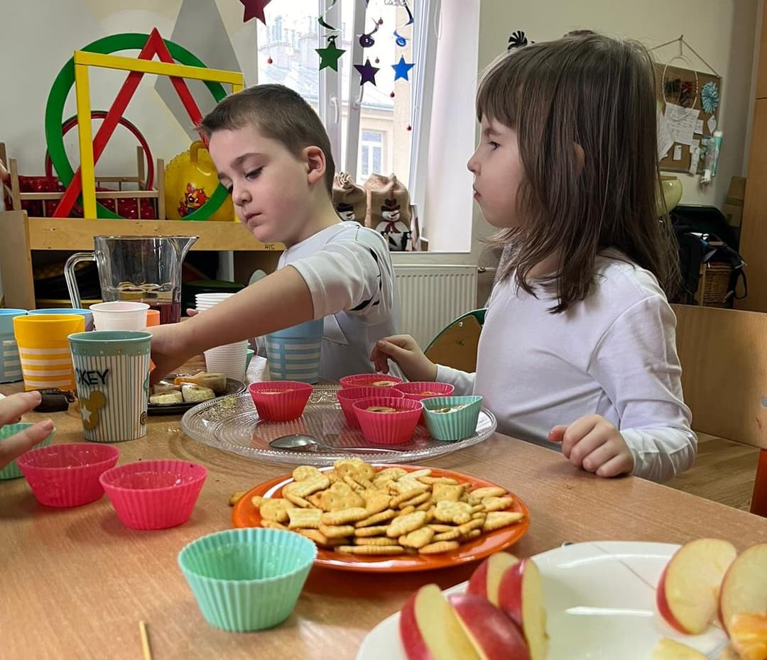 Karnawałowe spotkania | Dzieci prtzy stoliku podczas poczęstunku.jpg