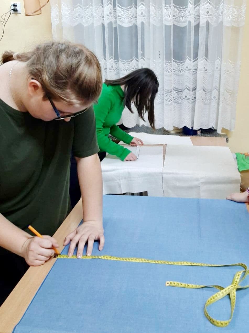 Zajęcia krawieckie w internacie | Dwie dziewczyny mierzą materiał.jpg