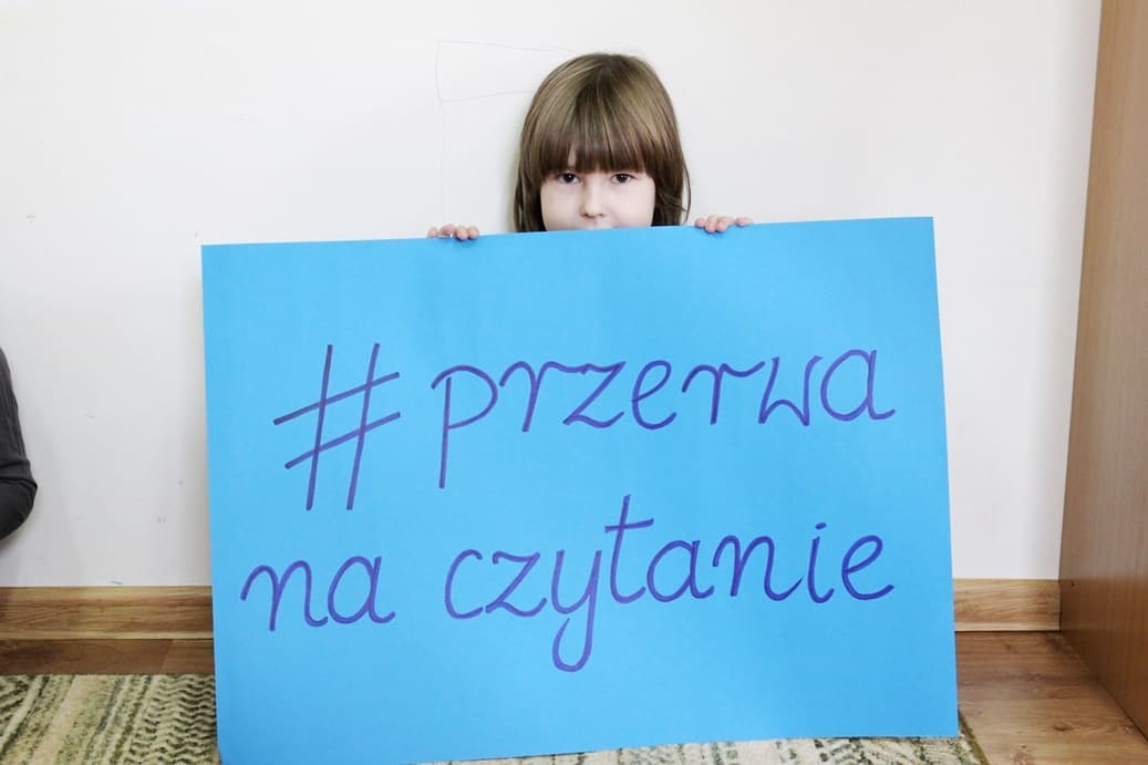 Zrób sobie przerwę na czytanie | Dziewczynka trzyma plakat z napisem hasztag przerwa na czytanie_.JPG