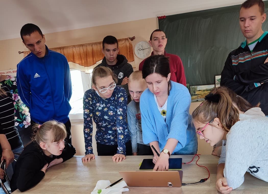 W świecie sztuki | Nauczyciel pokazuje coś uczniom na komoputerze .jpg