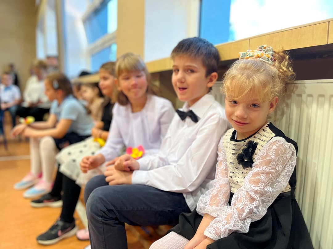 Świętujemy Dzień Edukacji Narodowej | Przedszkolaki siedzą na ławeczce i czekają na występ.JPG
