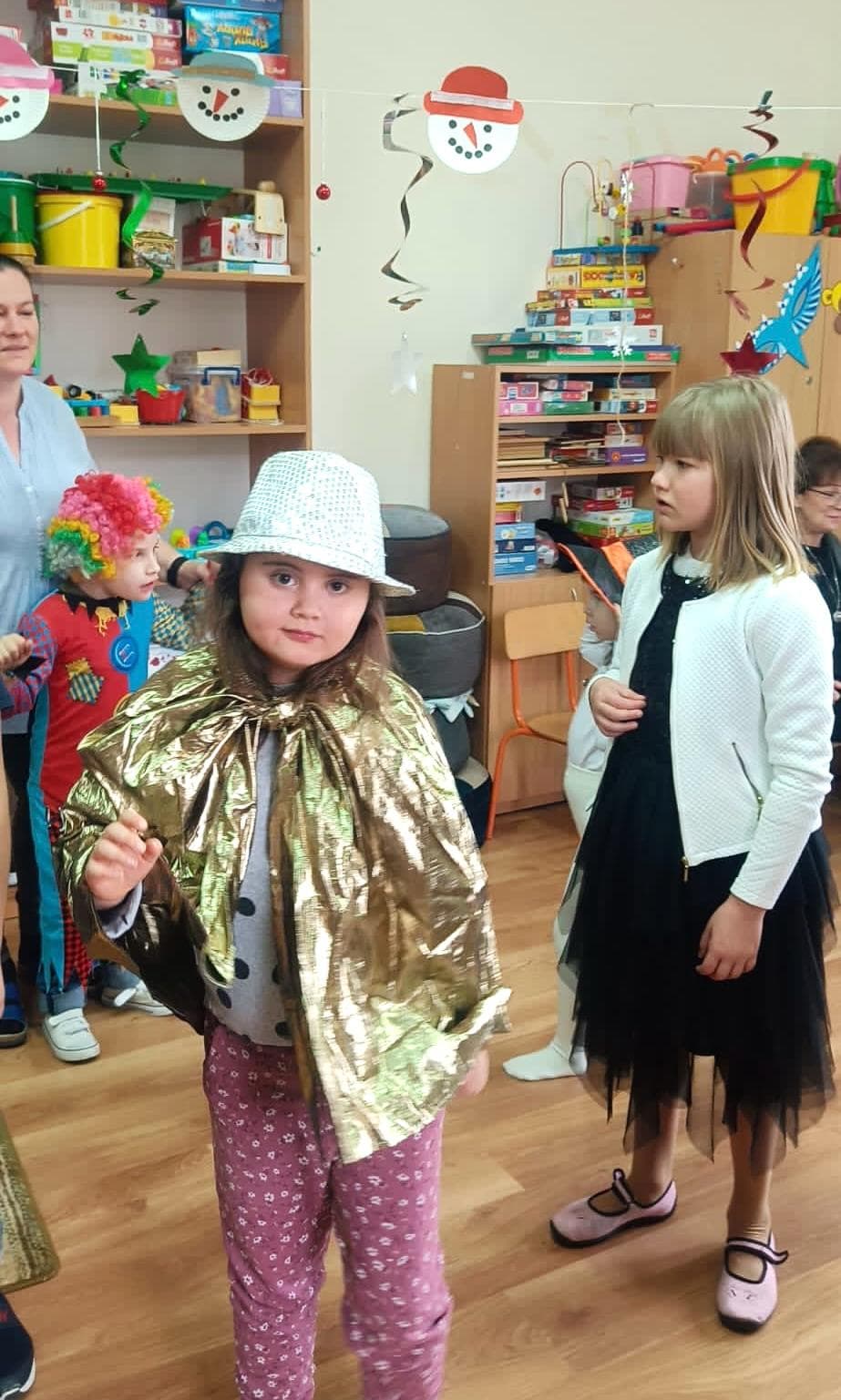 Karnawałowe spotkania | Dziewczynka w kapeluszu uśmiecha się do zdjęcia.jpg