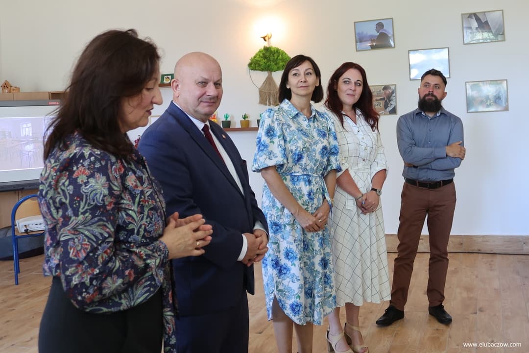 „Przyjazna przystań” | Pięć osób stoli w rzędzie na środku sali. kobieta na pierwszym planie przemawia.jpg