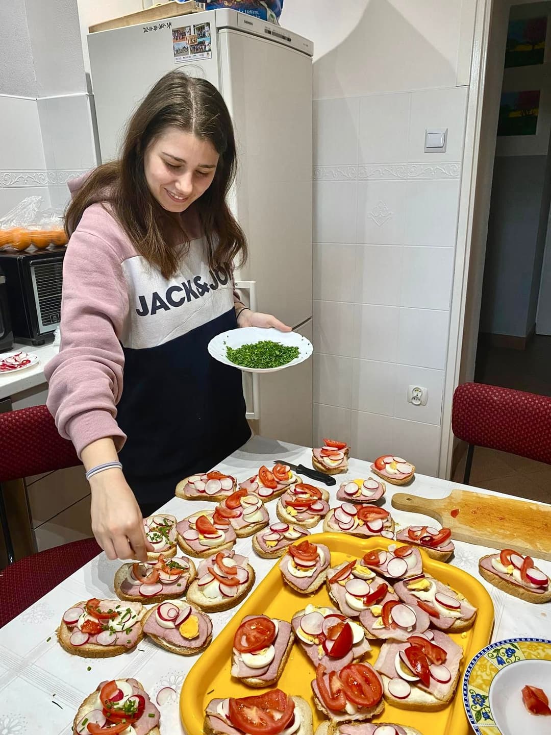 Trening samodzielności w Internacie | Uczennica posypuje kanapki szczypiorkiem.jpg