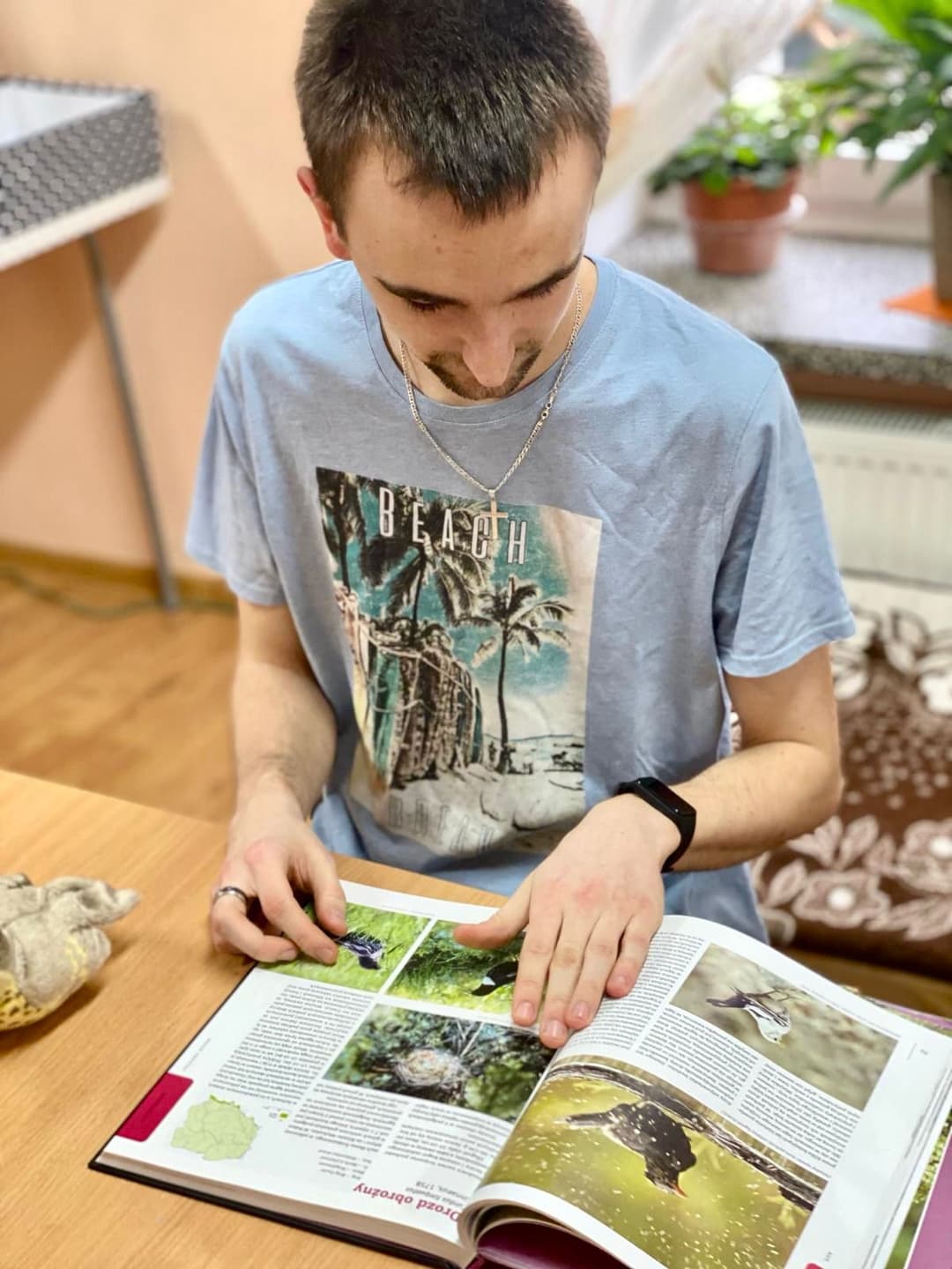 W świecie ptaków | Chłopach przegląda książkę.jpg