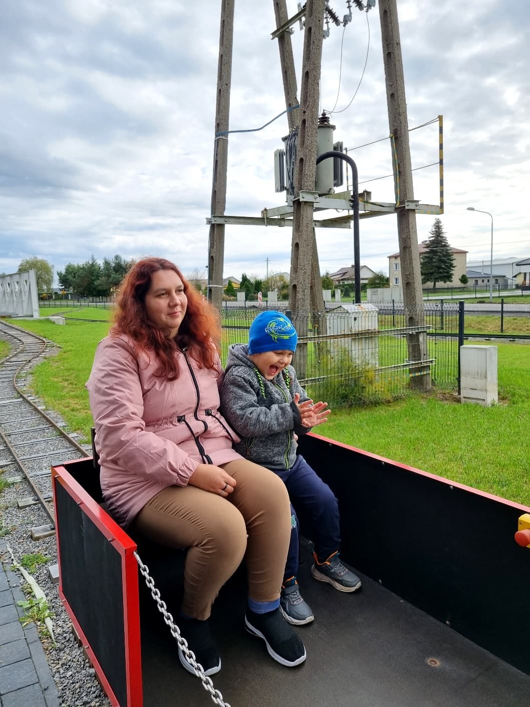 Przedszkolaki w Stacji Basznia i Kresowej Osadzie | Zadowolony chłopiec z mamą w wagoniku.jpg