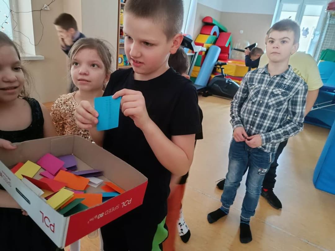 Zaczarowany dzień. | chlopiec losuje z pudełka kartkę .jpg