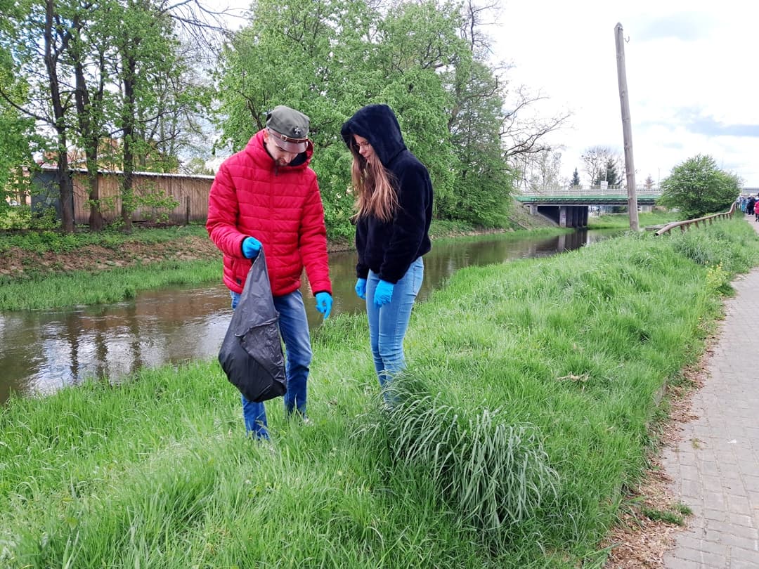 Czysta rzeka | GŁÓWNE Dwoje uczniów zbiera śmieci nad rzeką do worka .jpg