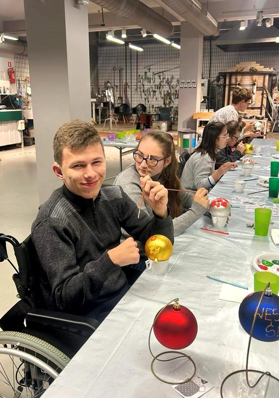 Szklane dziedzictwo Krosna | Uczeń uśmiecha się do zdjęcia podczas pracy.jpg