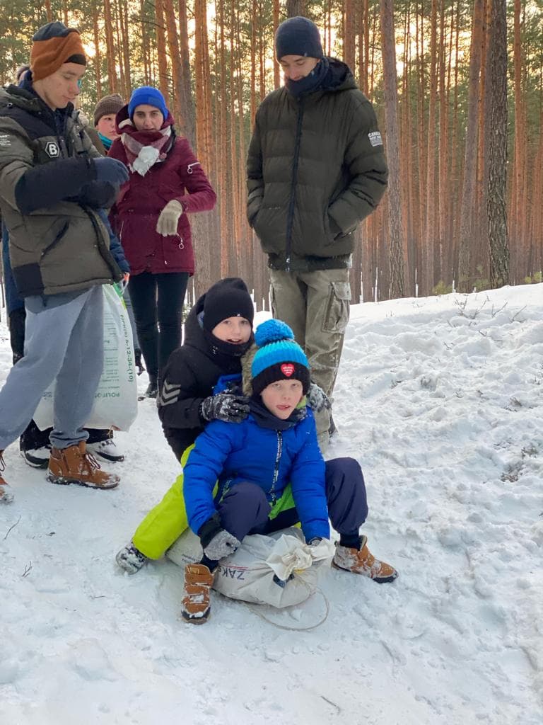 Kulig | Dzieci zjeżdżają z górki na worku z sianem .jpg