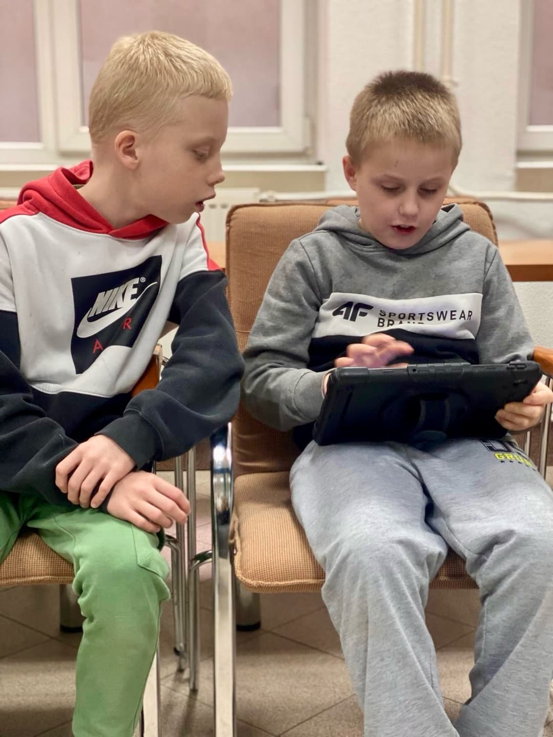 ROBOTYKA | Dwóch chłopców siedzi na krzesłach i ogladają tablet.jpg