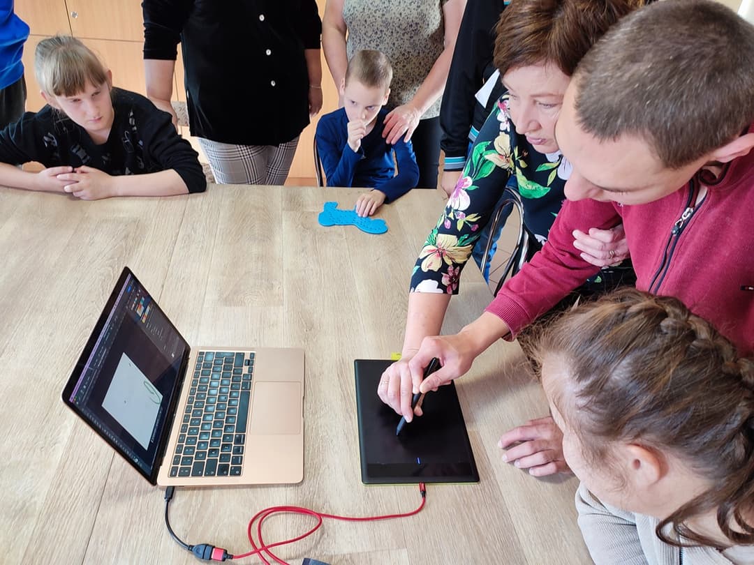 W świecie sztuki | Uczeń z pomocą nauczyciela rysuje na tablecie.jpg